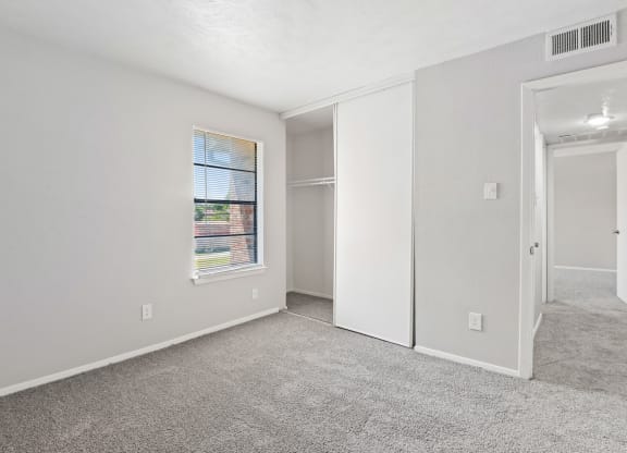 a bedroom with white walls and carpet