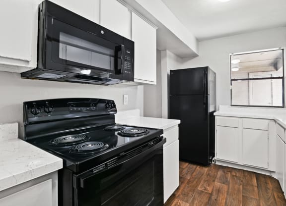 a kitchen with white cabinetry and black appliances