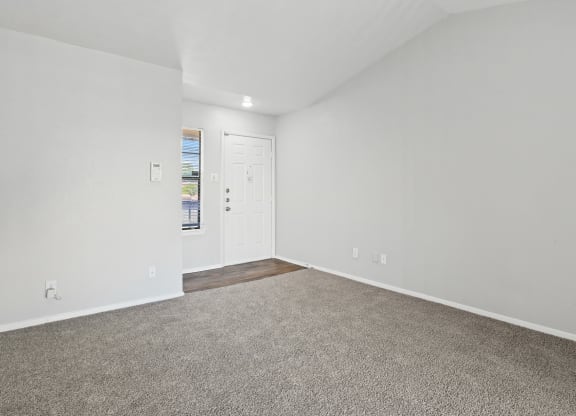 a bedroom with white walls and carpet