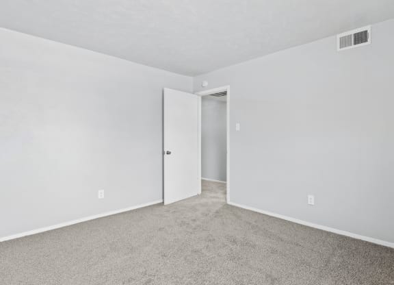 a bedroom with white walls and carpet