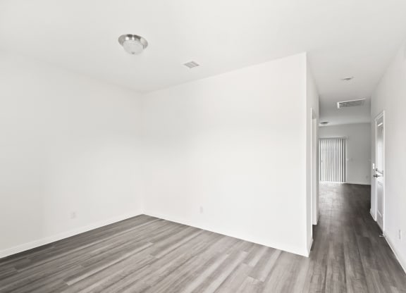 a bedroom with hardwood floors and white walls