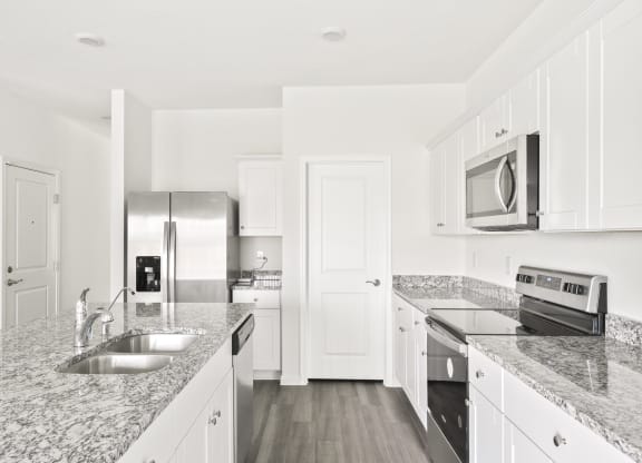 a kitchen with granite countertops and stainless steel appliances