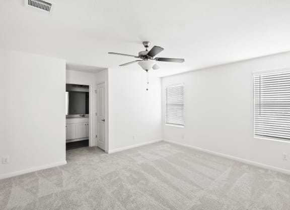an empty bedroom with a ceiling fan