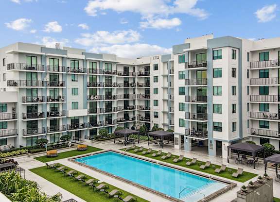 Pool area with apartment balconies overlooking the pool at Twenty2 West luxury apartments in Miami, FL