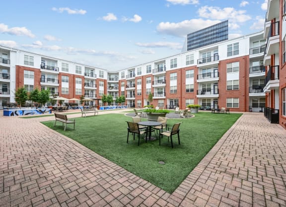 Outdoor courtyard with seating and landscaped gardens at The Grand at Upper Kirby apartments in Houston, TX