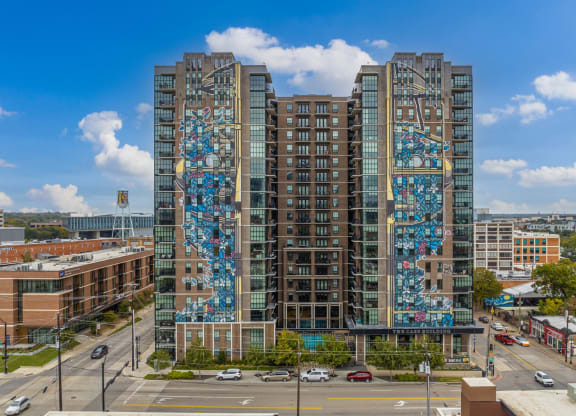 Front aerial view of The Case Building with art piece titled Garden Boy from PixelPancho, The Case apartments in Dallas, TX
