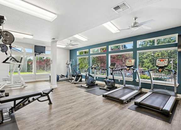 A gym with treadmills, weights, and exercise equipment at The Madison apartments in Olympia, WA