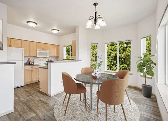 Virtually staged kitchen in the Jackson floor plan with a dining table at The Madison apartments in Olympia, WA