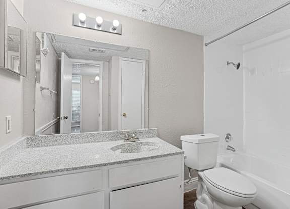 A1 bathroom with a sink, toilet, and bathtub at Vine Apartments in Arlington, TX