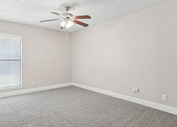 B1 bedroom with a ceiling fan and carpeted floor at Vine Apartments in Arlington, TX