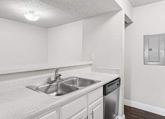 Upgraded A1 kitchen with a sink and a dishwasher at Vine Apartments in Arlington, TX