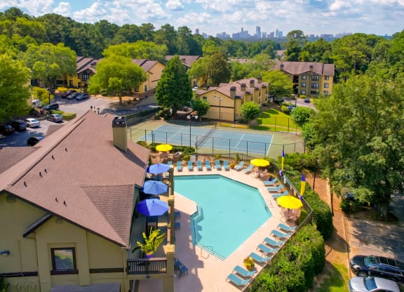 an aerial view of a resort style pool with lounge chairs and umbrellas