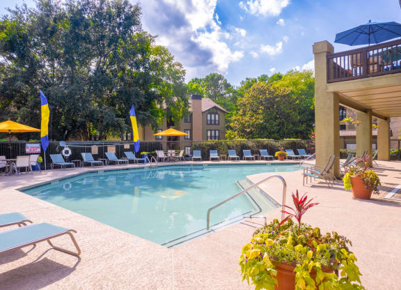 a swimming pool with lounge chairs and umbrellas at homewood suites by hilton