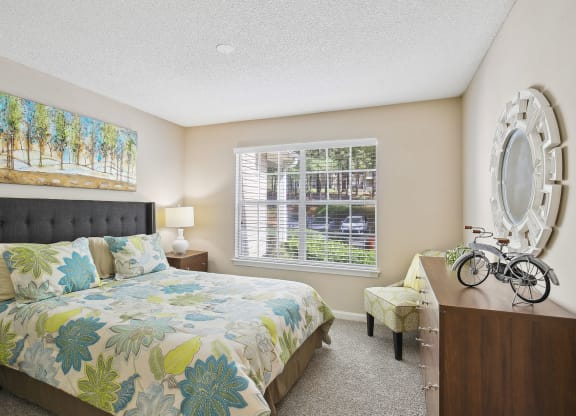 Model bedroom with a bed and a window at Wellington Ridge in Lawrenceville, GA