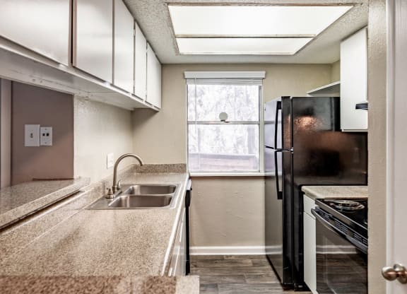 a kitchen with a sink and refrigerator and a window
