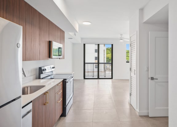 a kitchen with wooden cabinets and a white tiled floor
