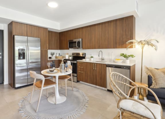 Kitchen in A1 Floor Plan with stainless steel appliances and a dining table at Westgate on University in Lauderhill, FL