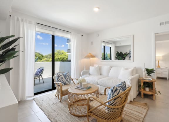 Living Room in B1 Floor Plan with white couch and sliding door to balcony at Westgate on University in Lauderhill, FL
