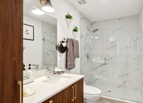 Bathroom in A2 Floor Plan with walk-in shower and wooden cabinets at Westgate on University in Lauderhill, FL