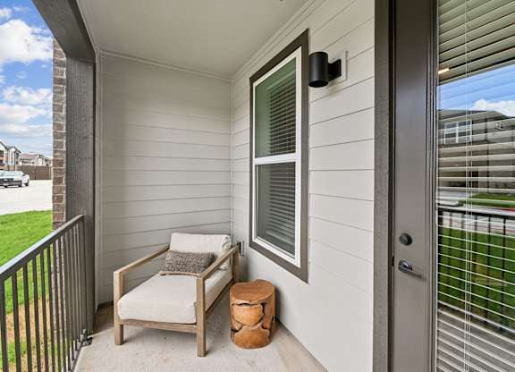 Balcony with a chair and an end table at Whispering Pines at Westdale Hills in Euless, TX