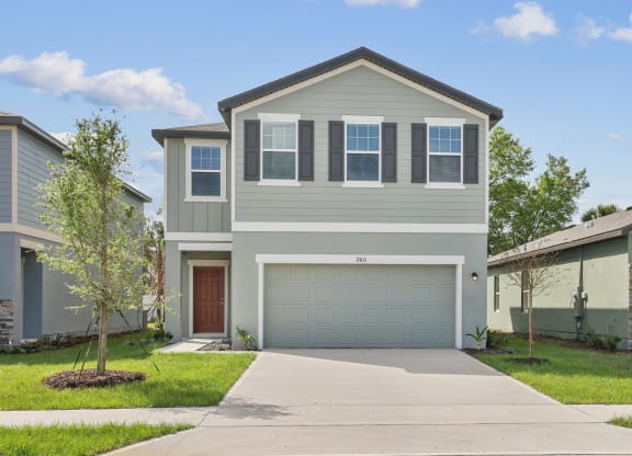 a home with a gray exterior and a brown garage door at Beacon at Woodland Village, DeLand Florida