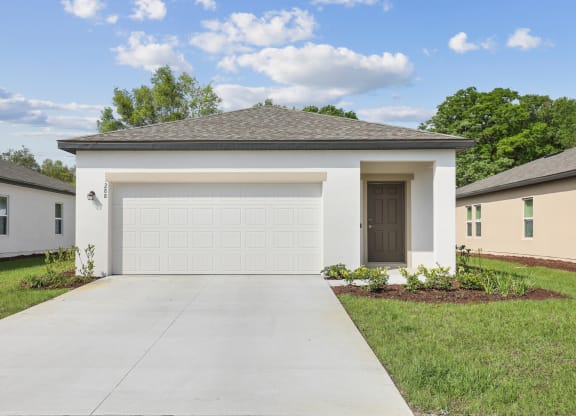 a home with a white garage door at Beacon at Woodland Village, DeLand, FL 32724