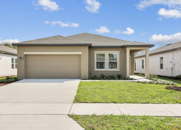 a house with a garage and a lawn at Beacon at Woodland Village, DeLand, FL