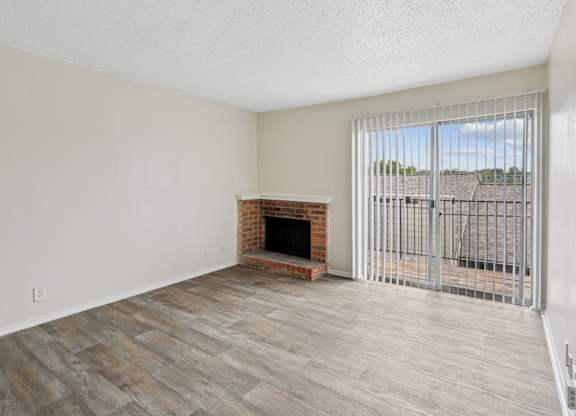 A2 living room with a fireplace and a sliding glass door at Westdale Pointe in Austin, TX
