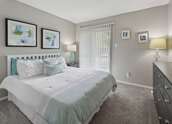 B1 bedroom with white bed and floor to ceiling sliding door at Westdale Pointe in Austin, TX