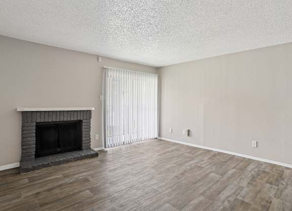 A5 living room with a fireplace and vinyl wood flooring at Windridge on the Parkway apartments in Dallas, TX