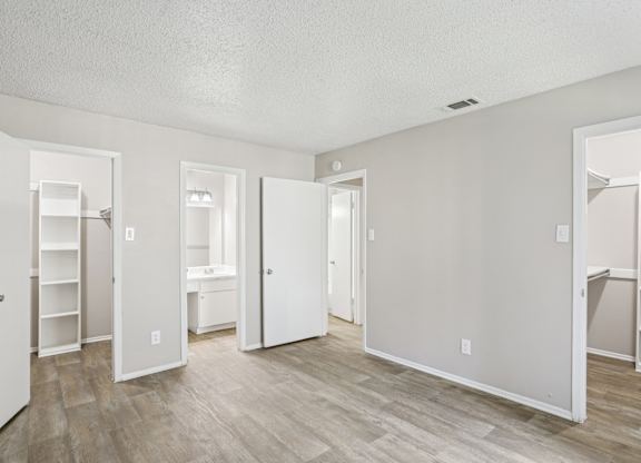 A6 bedroom with two walk-in closets at Windridge on the Parkway apartments in Dallas, TX