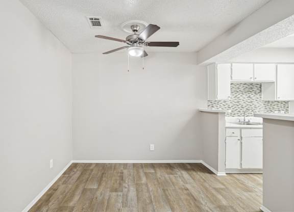 A6 dining room with a ceiling fan and vinyl wood flooring Windridge on the Parkway apartments in Dallas, TX.