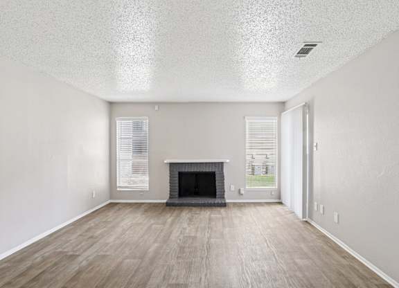 A6 living room with a fireplace and vinyl wood flooring Windridge on the Parkway apartments in Dallas, TX.