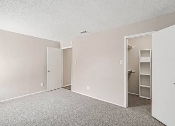 B6 bedroom with a closet, carpet, and white walls at Windridge on the Parkway in Dallas, TX