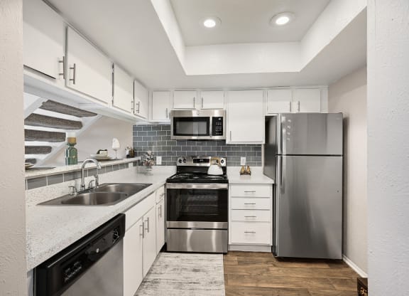 a kitchen with white cabinets and stainless steel appliances