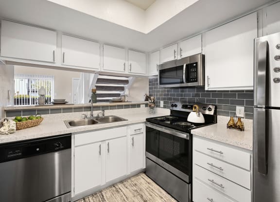 a kitchen with white cabinets and stainless steel appliances