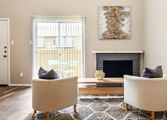 a living room with two chairs and a fireplace