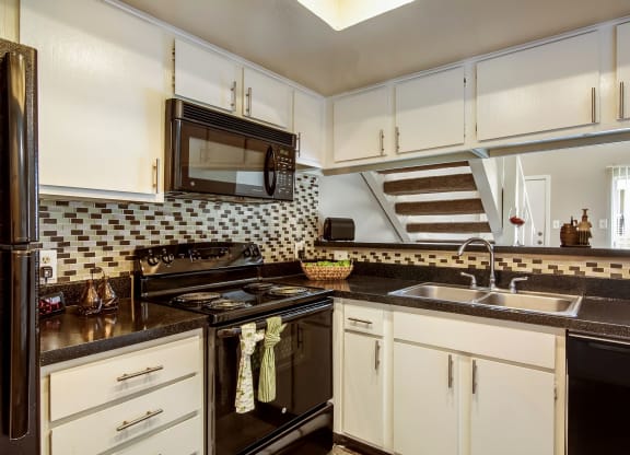 a kitchen with a sink and a stove and a microwave