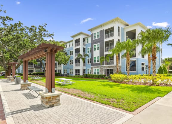 Bench seating by sidewalks and apartment buildings at Dunedin Commons apartments in Dunedin, FL
