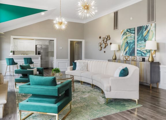 a living room with a white couch and turquoise chairs