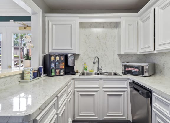 a kitchen with white cabinets and a white counter top