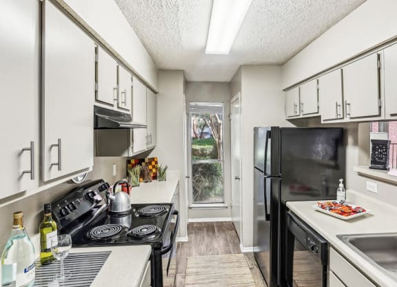 Model apartment kitchen with black appliances at Hunters Chase in Austin, TX