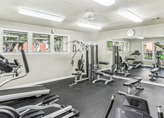 Fitness center with cable weight machines and cardio equipment at Hunters Chase in Austin, TX
