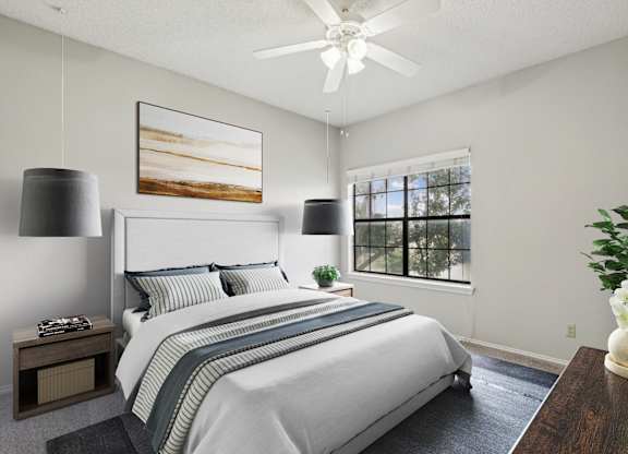 A carpeted bedroom in the B1 floorplan with a large bed, a ceiling fan, and a painting on the wall at Jefferson Creek Apartments in Irving, TX