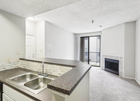 A1 floor plan kitchen with a sink and elevated counter overlooking the fireplace at Jefferson Creek Apartments in Irving, TX.