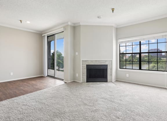 A2 floor plan living room with a fireplace and sliding glass doors that open to balcony at Jefferson Creek Apartments in Irving, TX.