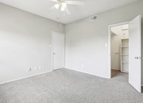 A2 floor plan bedroom with a  walk-in closet and a ceiling fan at Jefferson Creek Apartments in Irving, TX.