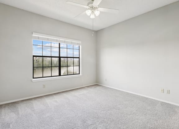 Bedroom 1 in the B1 floor plan with window and a ceiling fan at Jefferson Creek Apartments in Irving, TX.