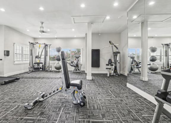 a gym with weights and cardio machines at Jefferson Creek in Irving, TX