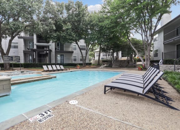 a swimming pool and lounge chairs at Jefferson Creek in Irving, TX
